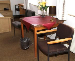 a table with chairs and a vase of flowers on it at Einfelder Hof garni in Neumünster