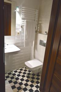 a white bathroom with a toilet and a sink at Ozonowane Apartamenty Next to Galeria Katowice in Katowice