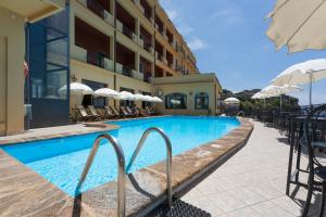 een zwembad in een hotel met stoelen en parasols bij Hotel Sole Castello in Taormina
