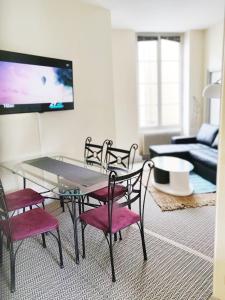 sala de estar con mesa de cristal y sillas en Chez Fanny - appartement de qualité hypercentre Cahors, en Cahors