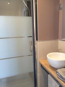 a bathroom with a glass shower and a sink at La Caroline in Corbie