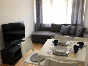 a living room with a table and a couch at CR Przytulny Apartament przy Pałacu Branickich in Białystok