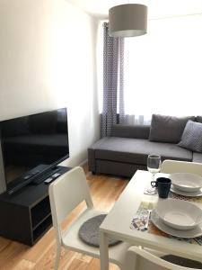 - un salon avec une table et un canapé dans l'établissement CR Przytulny Apartament przy Pałacu Branickich, à Białystok