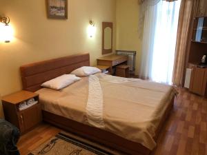 1 dormitorio con 1 cama con 2 almohadas en Вілла Анастасія en Truskavets