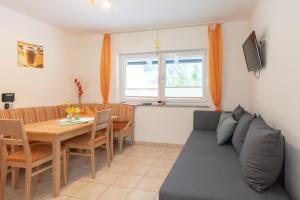 ein Wohnzimmer mit einem Sofa und einem Tisch in der Unterkunft Appartementhaus Monika in Flattach