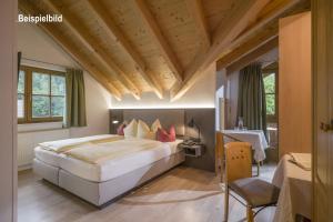 シュトゥンムにあるLa Pasta Hotel Restaurantの木製の天井のベッドルーム1室(大型ベッド1台付)