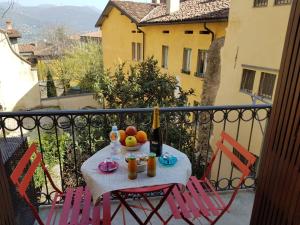 Una mesa con un bol de fruta en un balcón. en Bergamo Alta Guest House, en Bérgamo