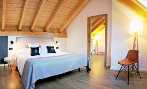 バレンシア・デ・アヌーにあるオテル ロ パイエールの大きなベッドと椅子のある寝室 +34枚の写真