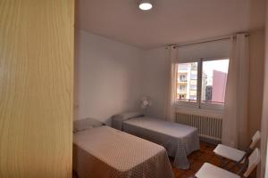 サン・フェリウ・デ・ギホルスにあるSant sebastià 3のベッド2台と窓が備わる小さな客室です。