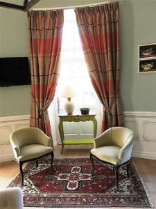 a living room with two chairs and a window at Domaine Plessis Gallu - vacation cottage rental in Azay-le-Rideau