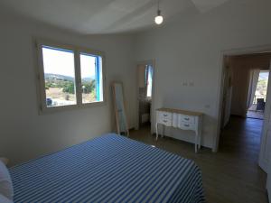 a bedroom with a blue and white bed and a window at Villino Blu Mare in San Teodoro