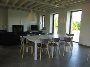 ein Esszimmer mit einem weißen Tisch und Stühlen in der Unterkunft Gîte familial à l'Aiguillon-sur-Vie in LʼAiguillon-sur-Vie + 26 Fotos