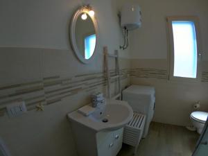 a bathroom with a sink and a mirror and a toilet at Villino Blu Mare in San Teodoro +25 photos