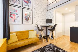 ein Wohnzimmer mit einem gelben Sofa und einem Tisch in der Unterkunft Leah Studios in Budapest