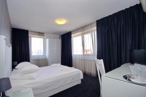 Un pat sau paturi într-o cameră la Hotel City