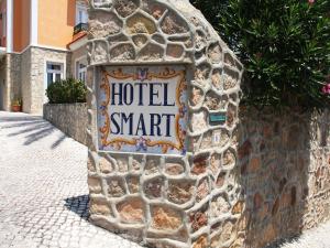 un panneau sur le côté d'un mur de pierre dans l'établissement Hotel Smart, à Estoril