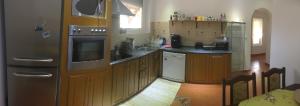 a kitchen with wooden cabinets and a stove top oven at Holiday Home Mia in Belá