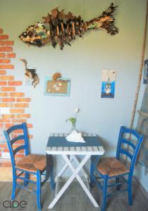 uma mesa com duas cadeiras azuis e uma mesa com em B&B PLANO DE LACZARULO em Acciaroli