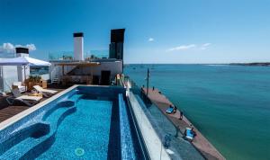 a swimming pool on top of a building next to the water at Hotel Boutique La Marquesina - Adults Only in Corralejo
