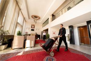 マラケシュにあるPalm Menara Hotel Marrakechの荷台をロビーに押し出す男