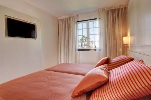 a hotel room with a bed and a window at Grupotel Club Menorca in Son Xoriguer