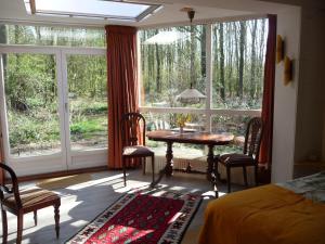 a bedroom with a table and chairs in front of a window at Selatuinen in Appelscha