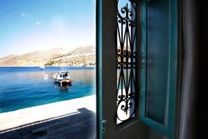 a door with a view of a boat in the water at SeaMe Houses in Symi