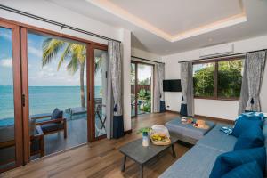 a living room with a view of the ocean at NH Collection Samui Peace Resort in Bophut