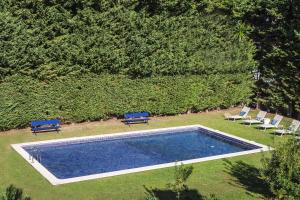 an overhead view of a swimming pool with two blue benches at The Seafront Manor by The Getaway Collection in Cascais