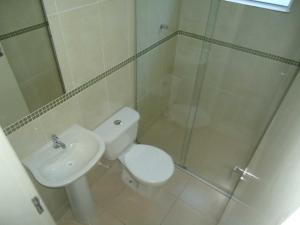 uma casa de banho com um chuveiro, um WC e um lavatório. em Pousada Clariô em Bertioga