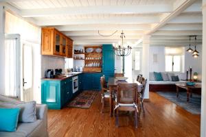 a kitchen with blue cabinets and a table and chairs at SeaMe Houses in Symi