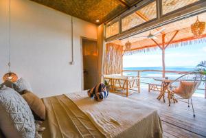 a bedroom with a bed and a view of the ocean at Le Cliff Bali in Uluwatu