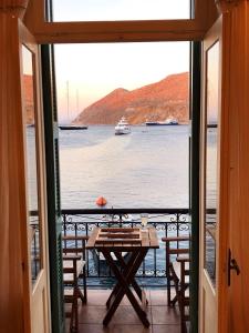 a room with a table and a view of the water at SeaMe Houses in Symi