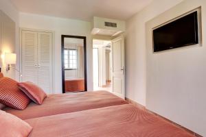 a bedroom with a bed and a flat screen tv at Grupotel Club Menorca in Son Xoriguer