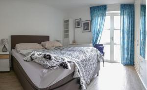 1 dormitorio con 1 cama grande y cortinas azules en ruhige Ferienwohnung mitten in Wiesbaden, en Wiesbaden
