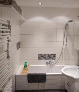 ruhige Ferienwohnung mitten in Wiesbaden في فيسبادن: حمام أبيض مع حوض استحمام ومغسلة +18 صورة