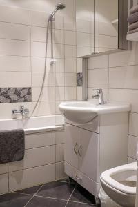 ruhige Ferienwohnung mitten in Wiesbaden في فيسبادن: حمام أبيض مع حوض ومرحاض