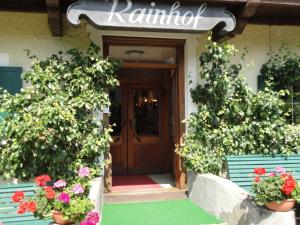 a front door of a house with flowers and plants at Pension Rainhof in Kitzbühel
