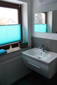 bagno con lavandino bianco e specchio di FeWo Topas Balingen a Balingen