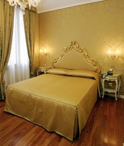 a bedroom with a bed with a gold bed frame at Casa Pisani Canal in Venice