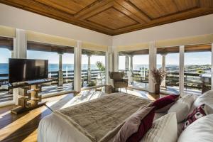 a bedroom with a bed and a tv and windows at The Seafront Manor by The Getaway Collection in Cascais