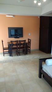 a living room with a dining room table and a television at Casa Magnolias in Tandil