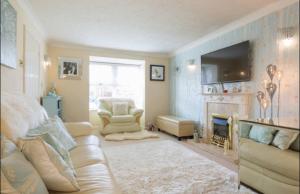 a living room with a couch and a fireplace at Comfy private room in shared house in Cambridge