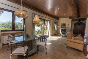 a dining room with a glass table and chairs at La Casona del Torcon in Navahermosa
