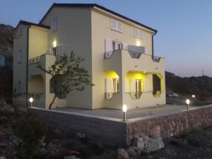 ein großes weißes Haus mit Lichtern davor in der Unterkunft Apartmani Prpić in Sveti Juraj