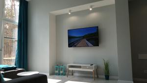 a living room with a tv on a wall at Apartament 4 przy Parku Leśnym in Polanica-Zdrój