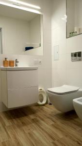 a white bathroom with a toilet and a sink at Apartament 4 przy Parku Leśnym in Polanica-Zdrój