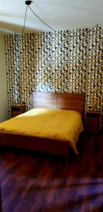 1 dormitorio con 1 cama con colcha amarilla en B&B del Lago en Ispra