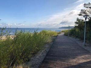 drewniana ścieżka obok plaży z oceanem w obiekcie Blue Sea Apartment w mieście Międzyzdroje