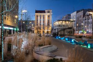 a city street at night with blue benches and buildings at Jakubowy Hotel in Gdynia